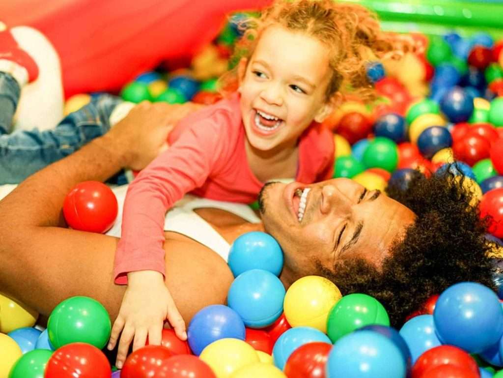 Parent and child playing in ball pit